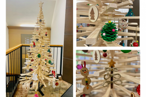 Smreka iz lesenih desk, okrašena z ročno izdelanimi okraski iz naravnih in odpadnih materialov.
