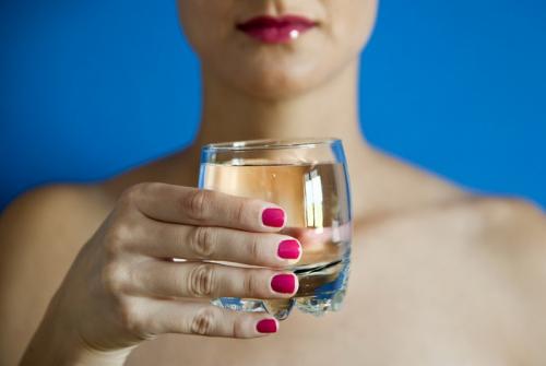 Kozarec z vodo v ženski roki.