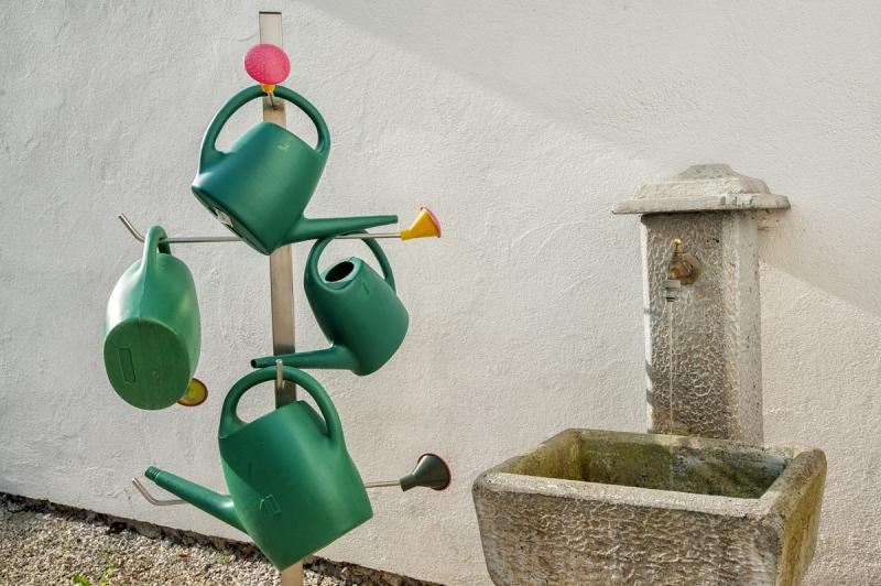 Stojalo za zalivalke in fontana na pokopališču.