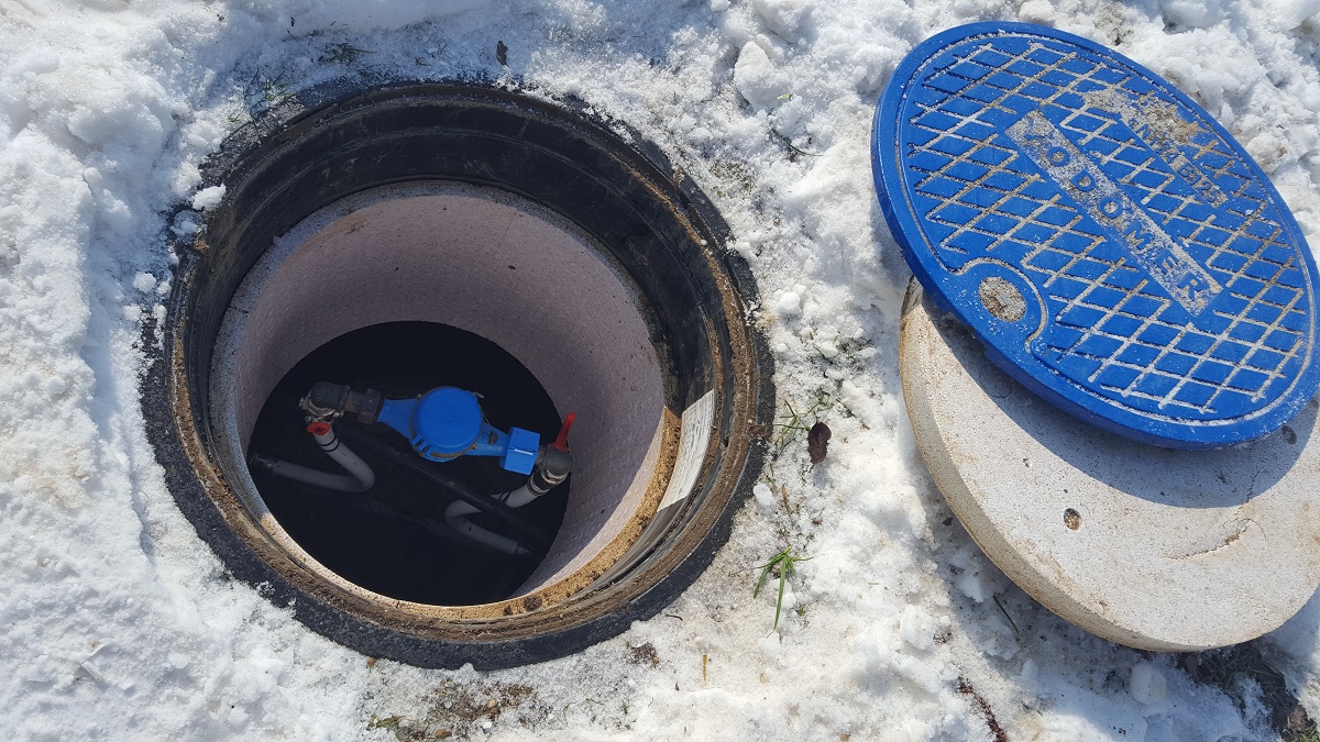 Odprt vodomerni jašek na snegu